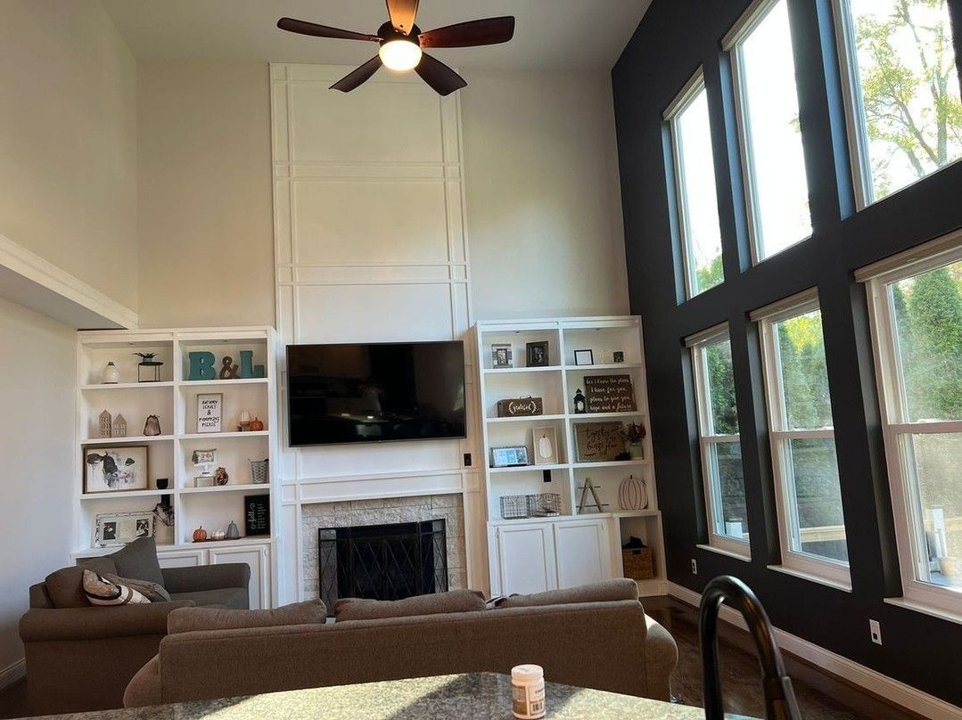 A living room with a fireplace and a ceiling fan