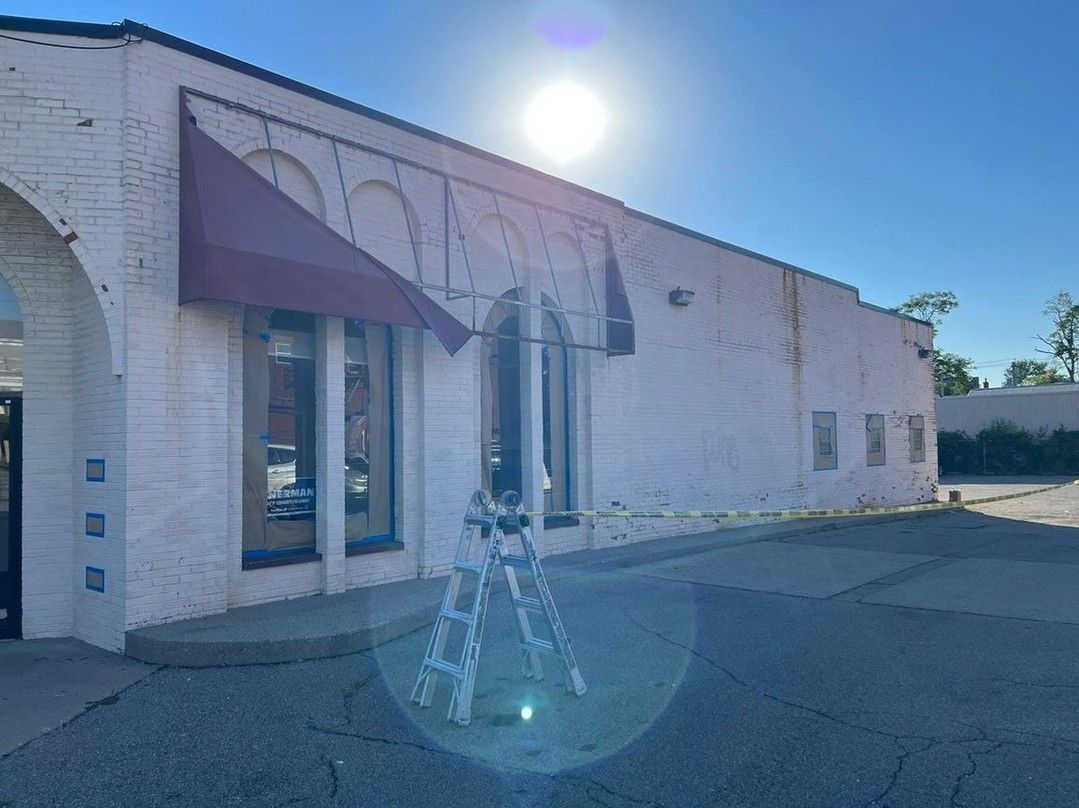 A white building with a red awning on the side of it.