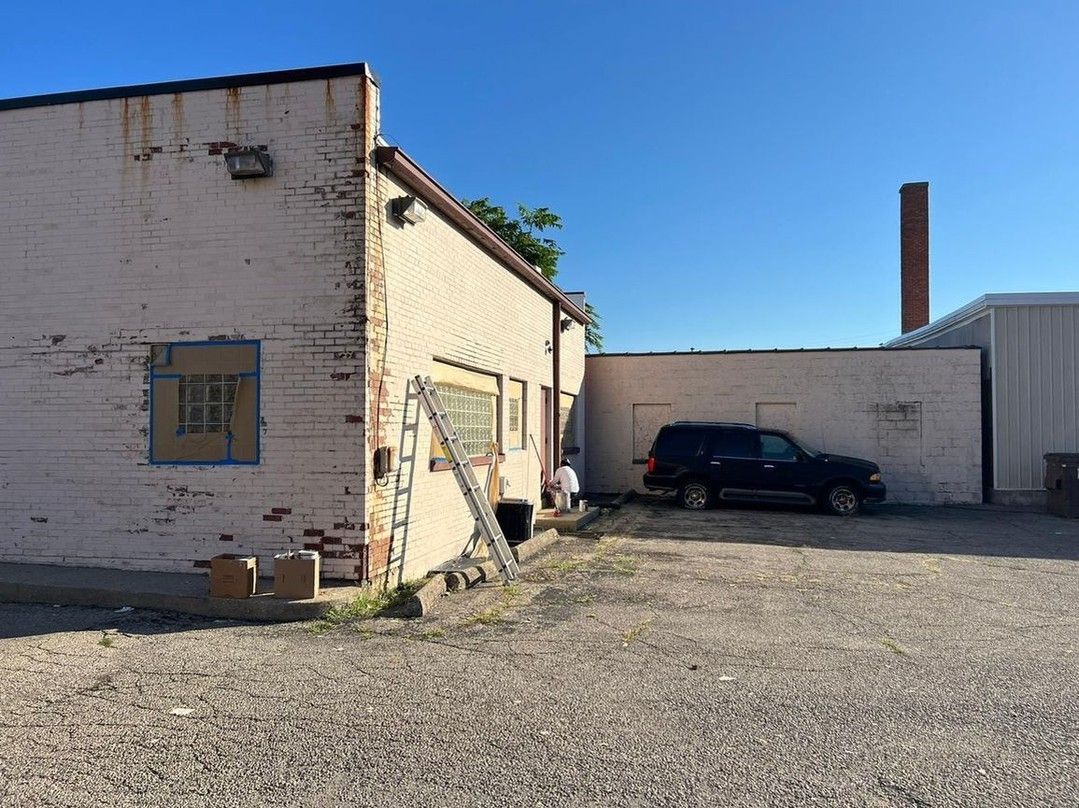 A car is parked in front of a brick building.