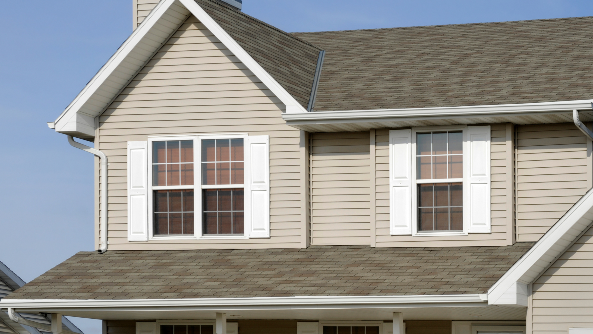 A house with a brown roof and white shutters