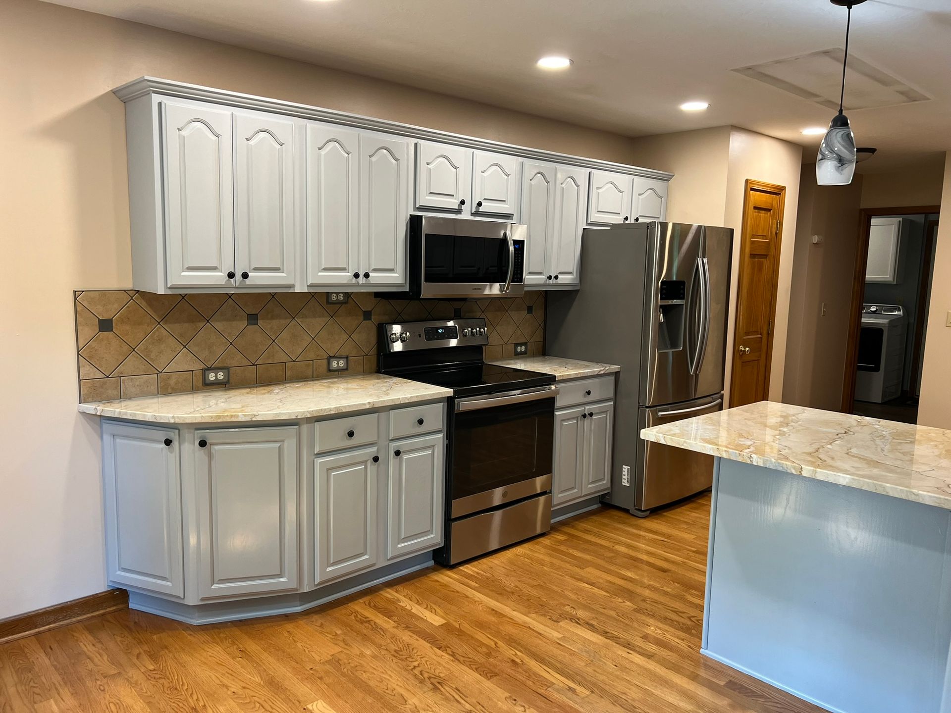 A kitchen with white cabinets and stainless steel appliances.