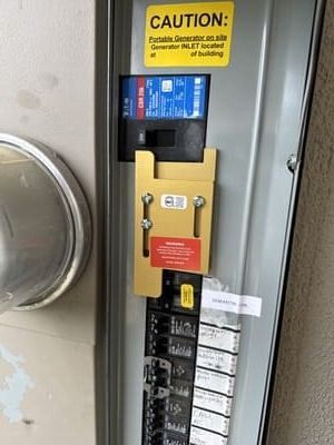 Electrical panel with a yellow safety bracket and warning signs.