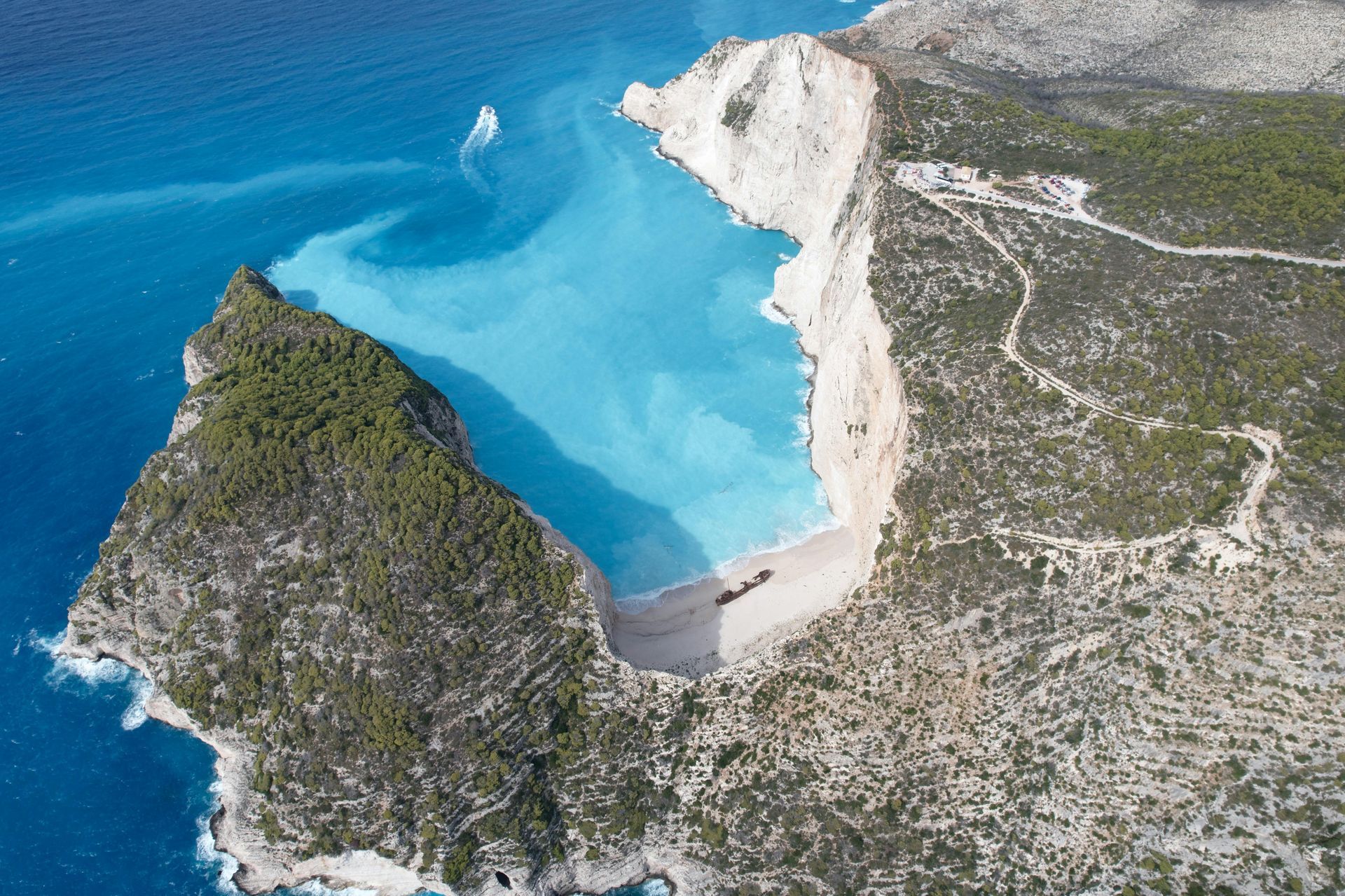 Aerial view of Navagio Beach, Zakynthos, Greece; turquoise water, white cliffs, small boat.
