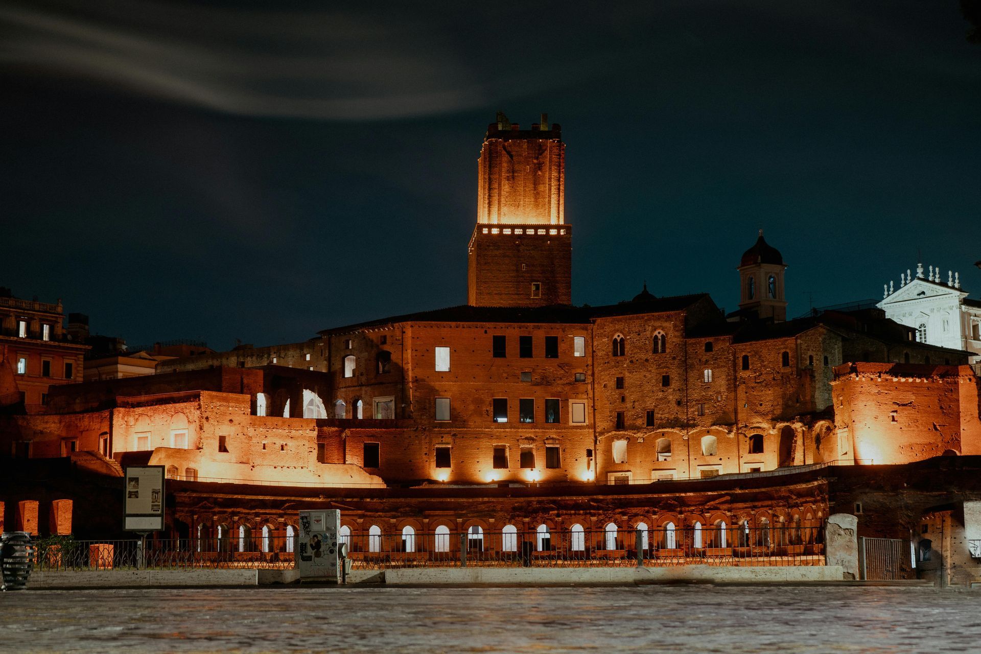 Night view of illuminated ancient Roman ruins in Rome, Italy.