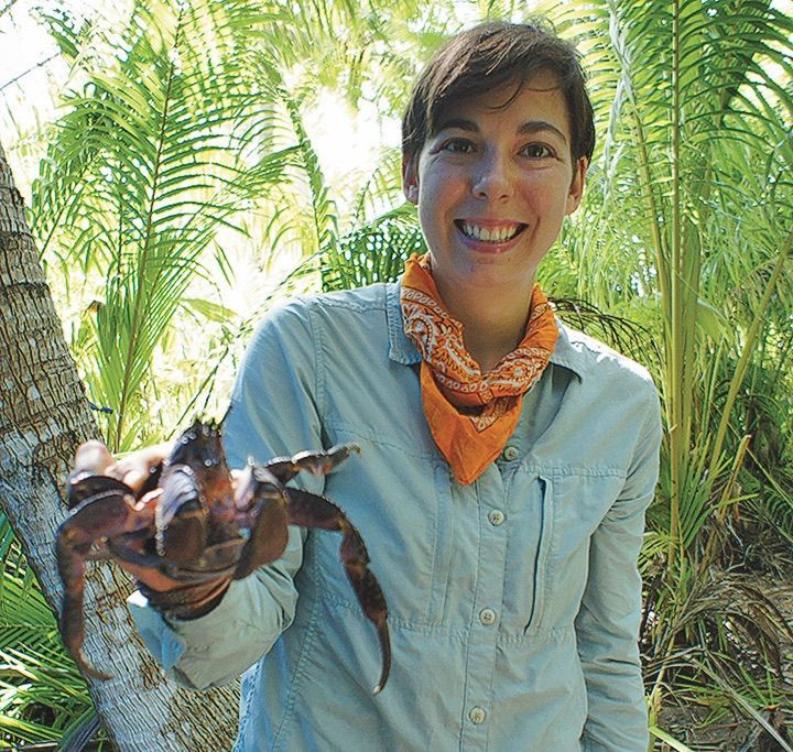 Sara Cramb on the atoll of Rakahanga holding a mischievous coconut crab