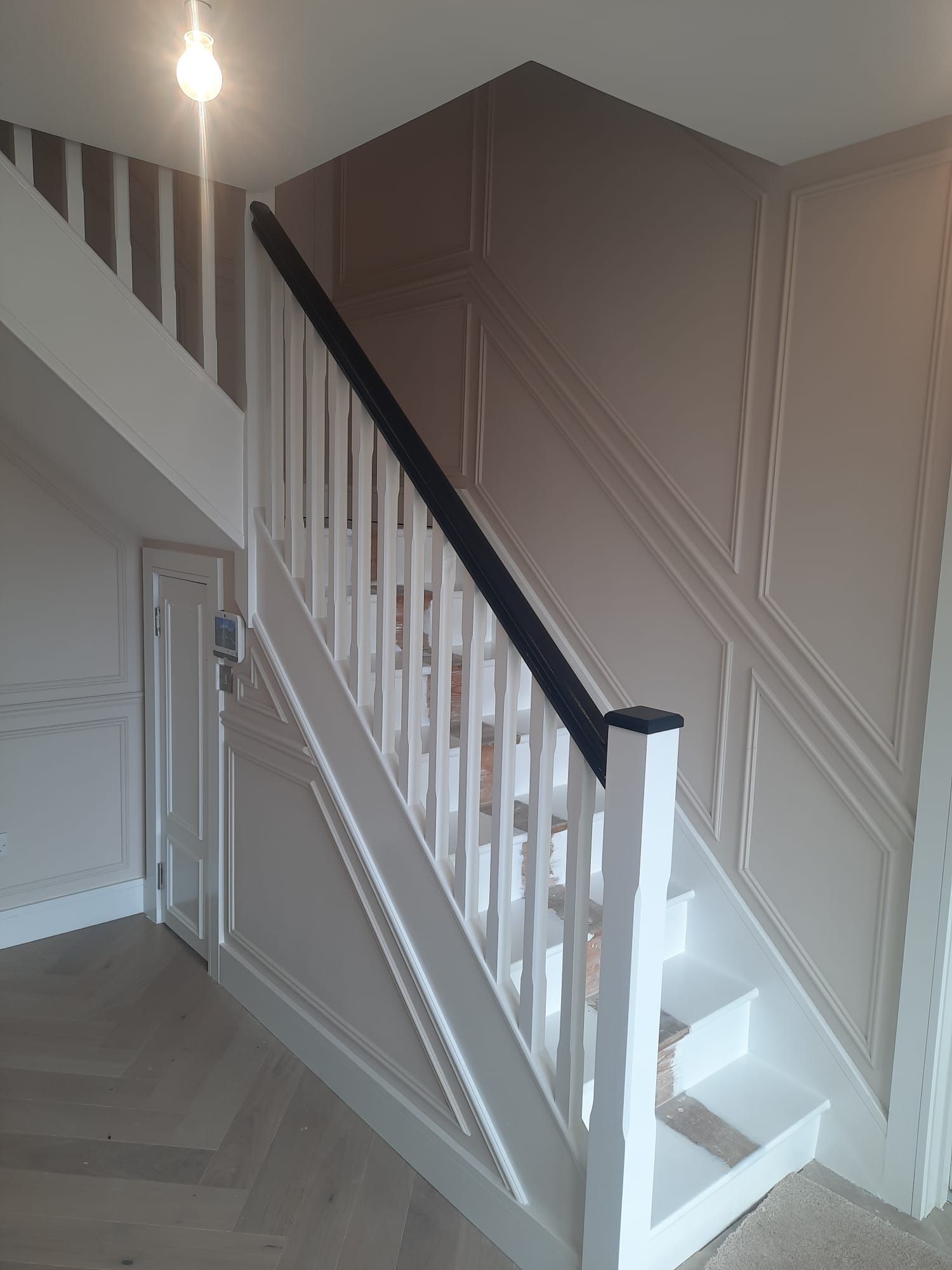 A white staircase with a black railing in a room.