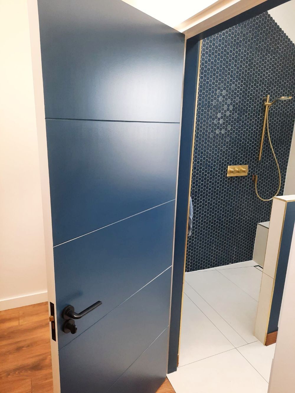 A blue door is open to a bathroom with a shower.