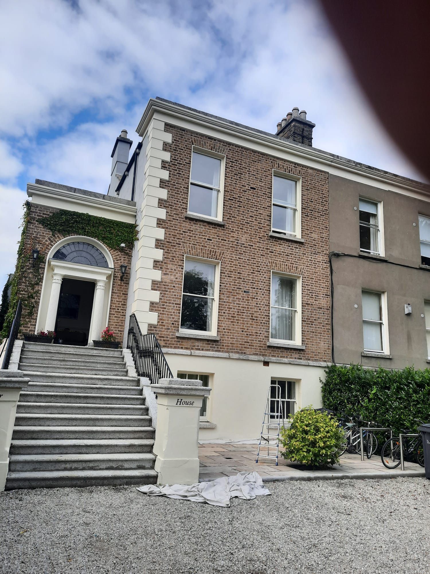 A large brick building with stairs leading up to the front door.