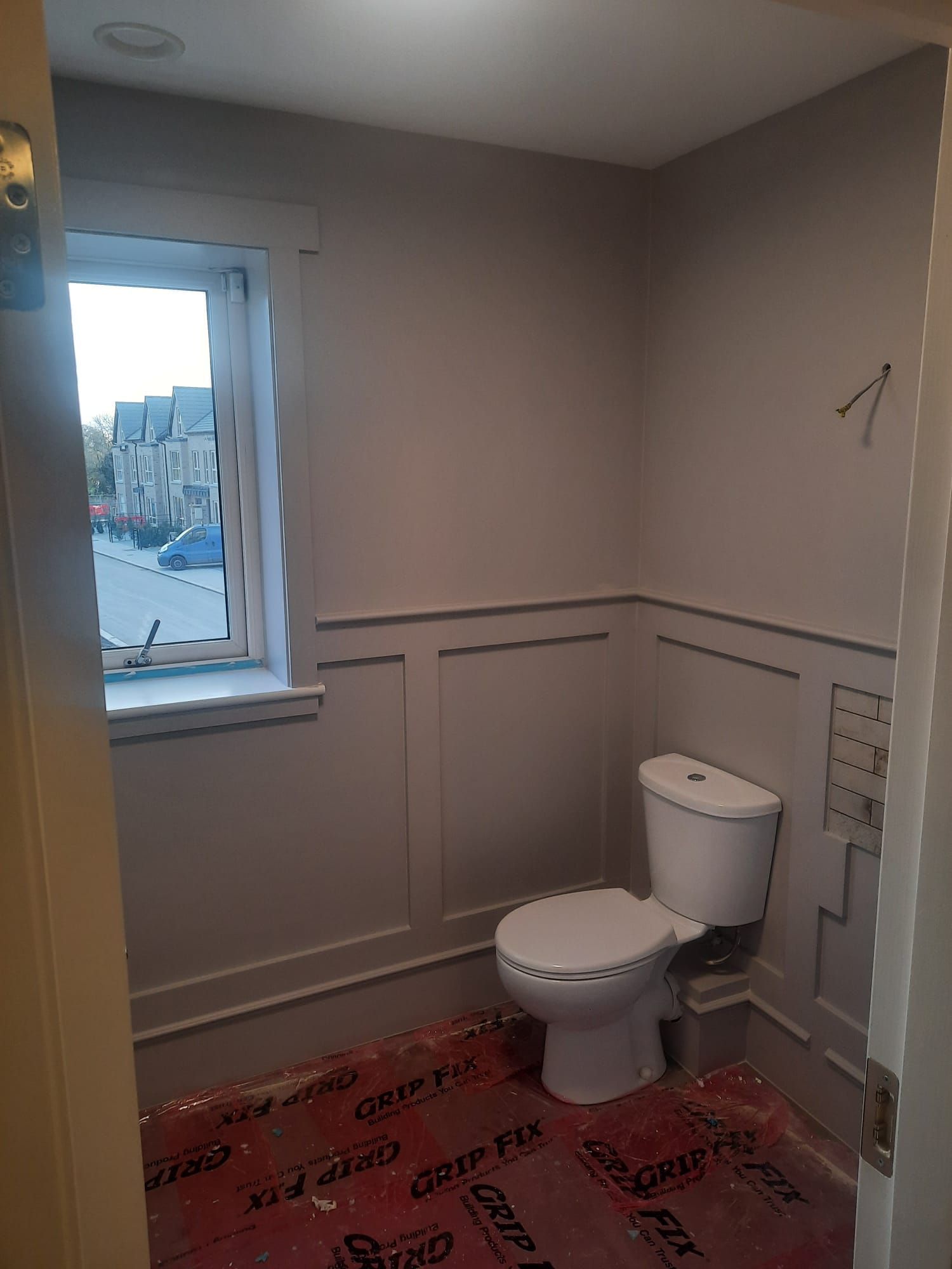 A bathroom with a toilet and a window.