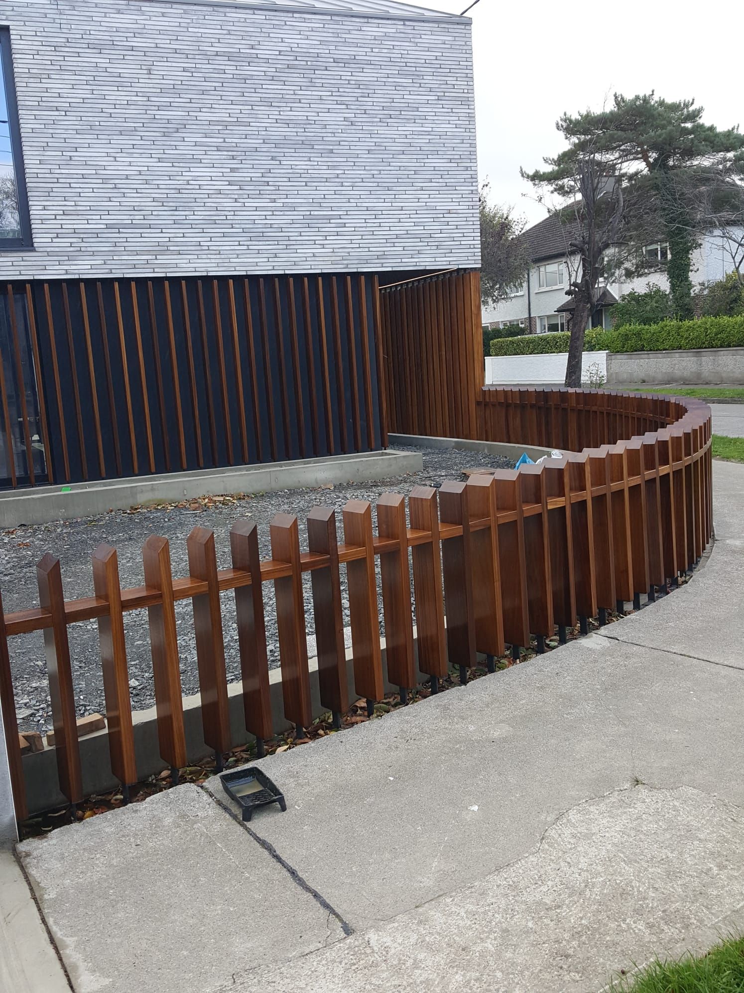 A wooden fence is sitting on the sidewalk in front of a house.