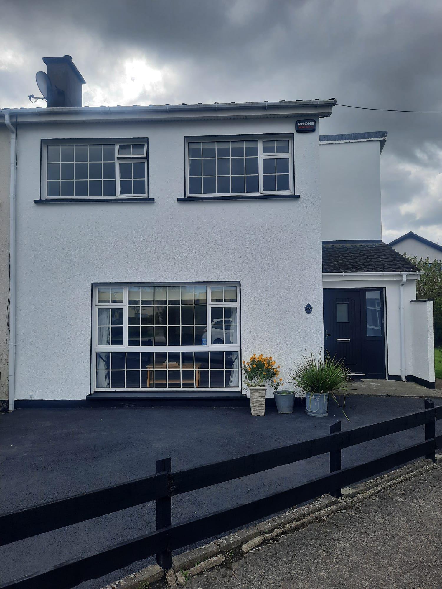 A white house with a black fence in front of it