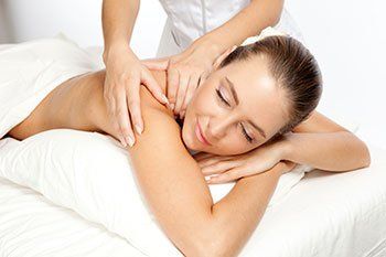 Picture of a woman getting a massage with her eyes closed.