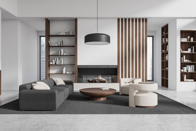 Un soggiorno moderno con divano grigio scuro, poltrone color crema chiaro, tavolino da caffè in legno e scaffalature a muro.