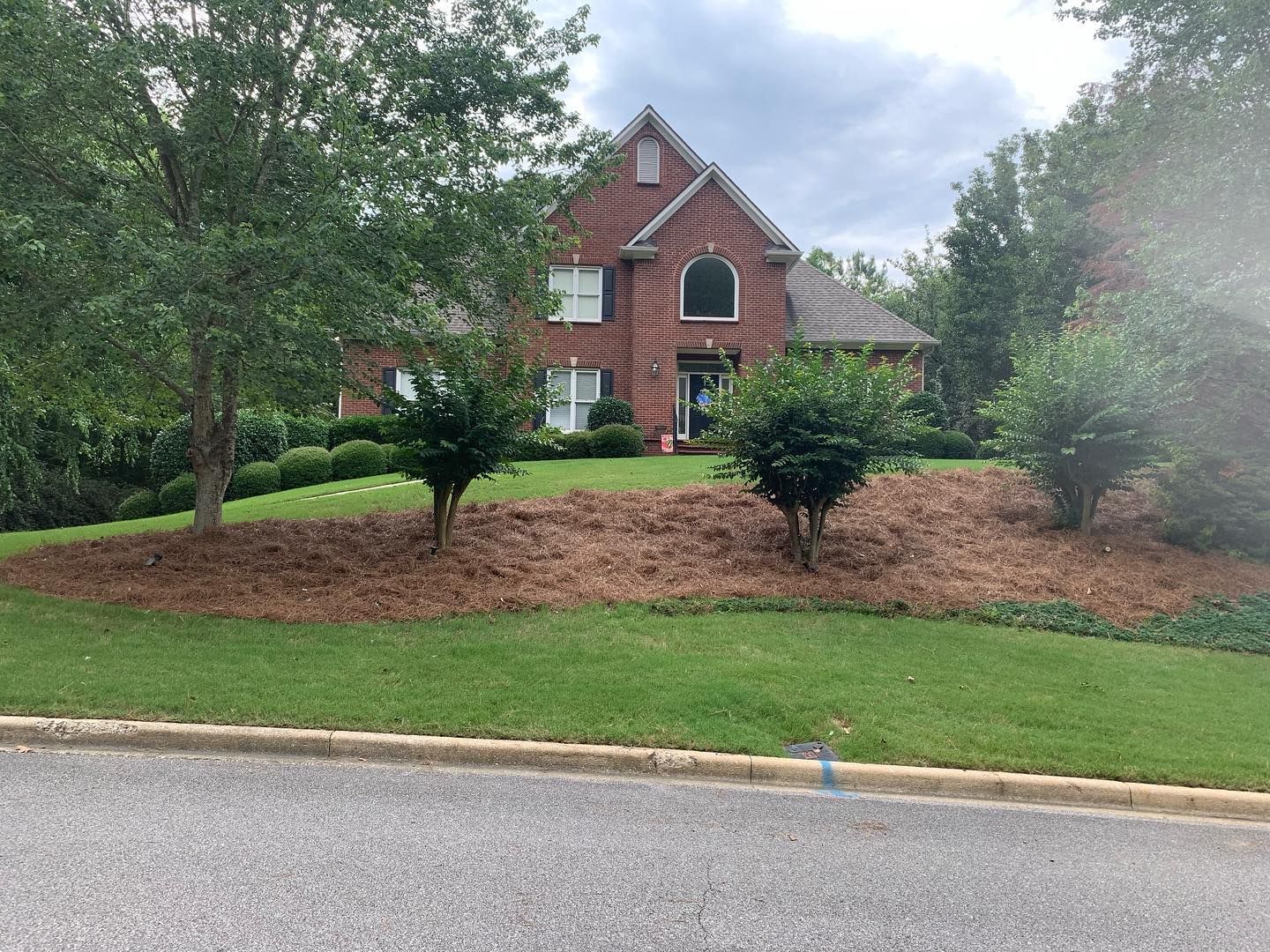 A large brick house with a lot of trees in front of it