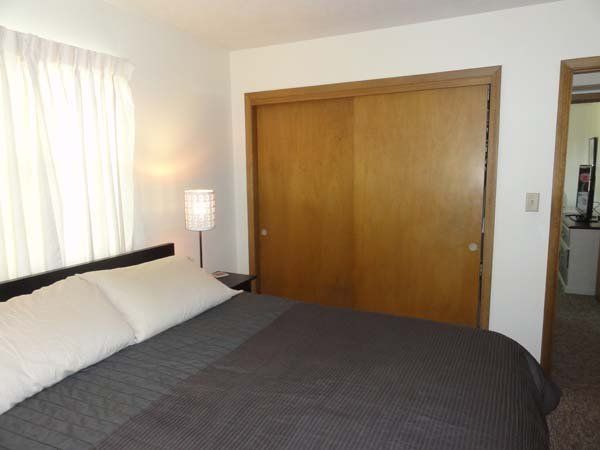 One Bed With Wooden Cabinet — Manhattan, KS — Plaza West Apartments