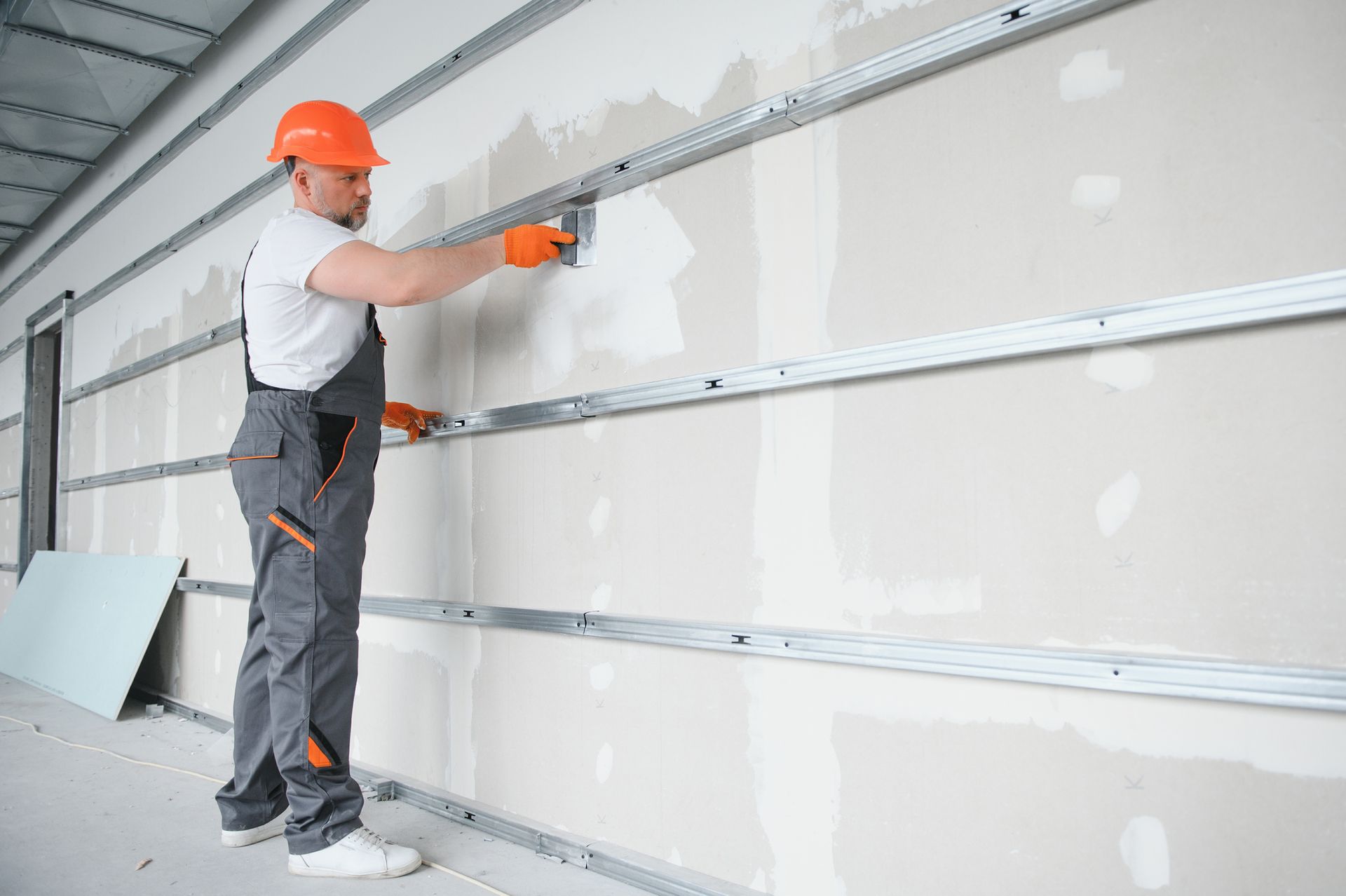 A man is plastering a wall with a spatula.