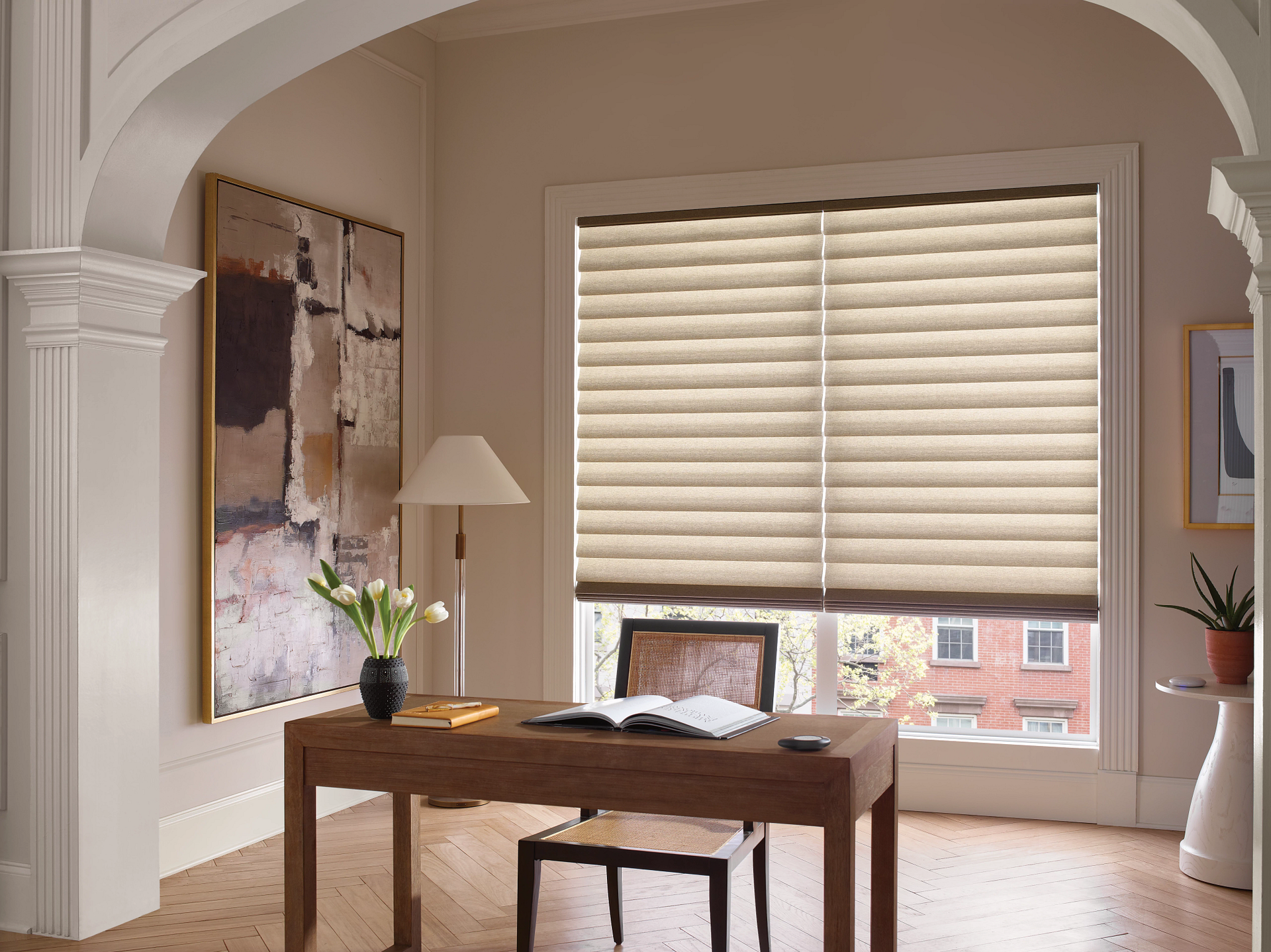 Bright minimalist room with wooden desk, lamp, potted plant, and large window blinds.