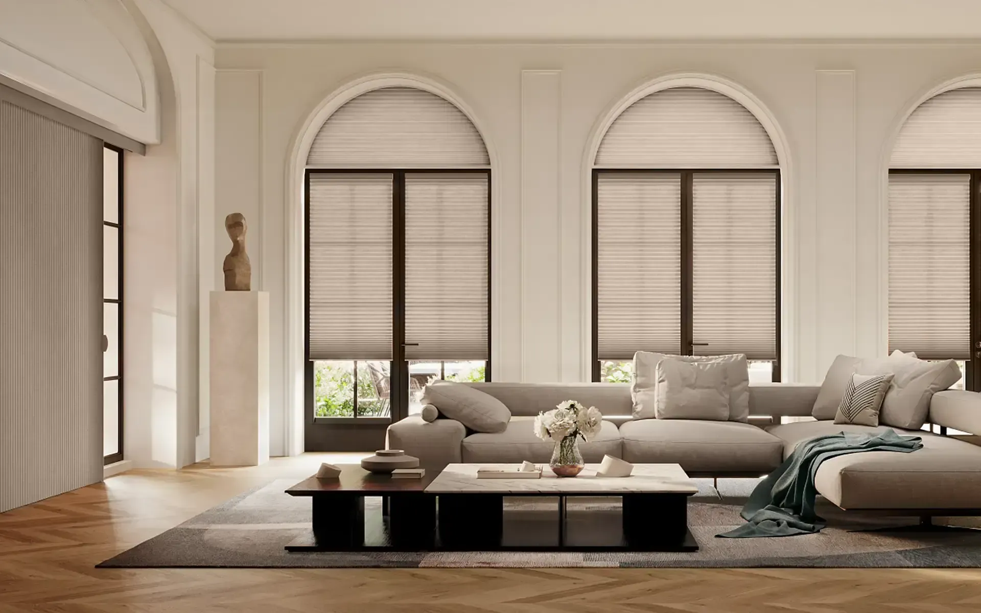Bright minimalist living room with arched windows, neutral sofas, and a low black coffee table