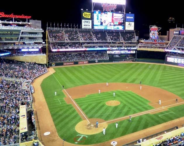 A baseball field with a budweiser sign in the background