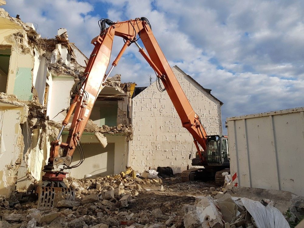 Orange Excavator Demolishing a Building — Walsh Demolition Pty Ltd in Tamworth, NSW