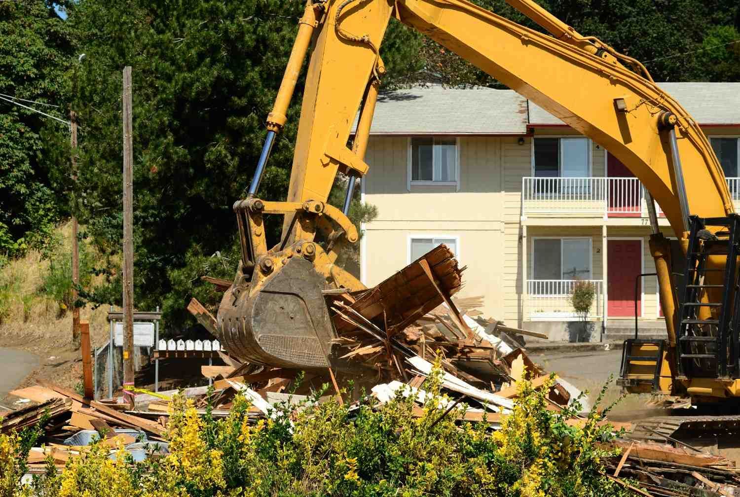 Yellow Excavator Demolishing a Multi-Unit Residential Building — Walsh Demolition Pty Ltd in Kyogle, NSW