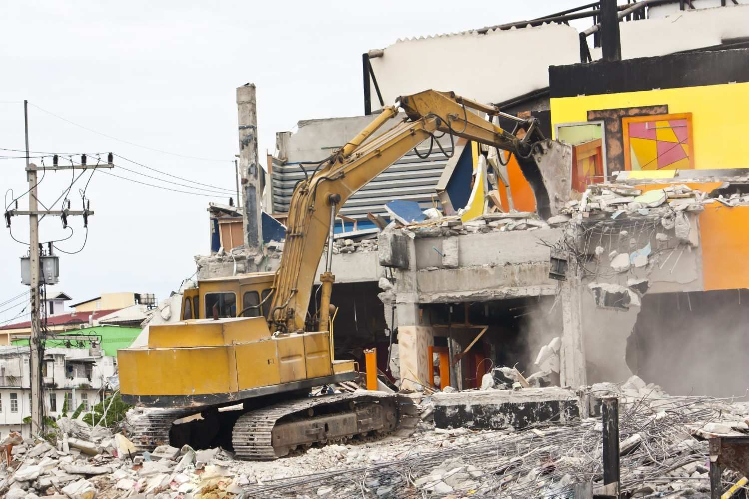 A Yellow Excavator Demolishes a Building, Debris Scattered — Walsh Demolition Pty Ltd in Kyogle, NSW