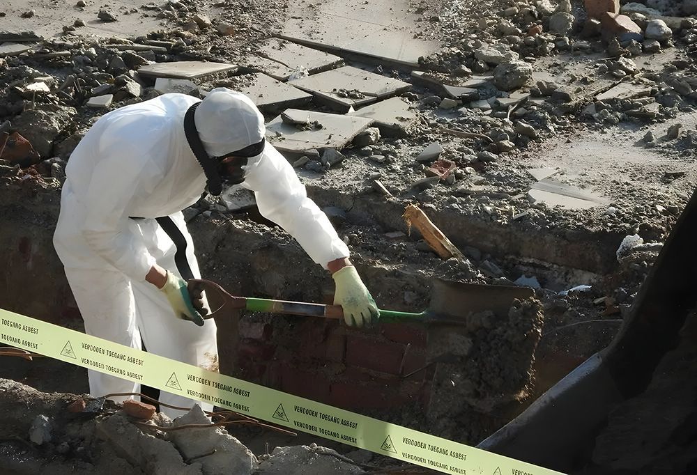 Person in Hazmat Suit Inspects Debris with a Tool