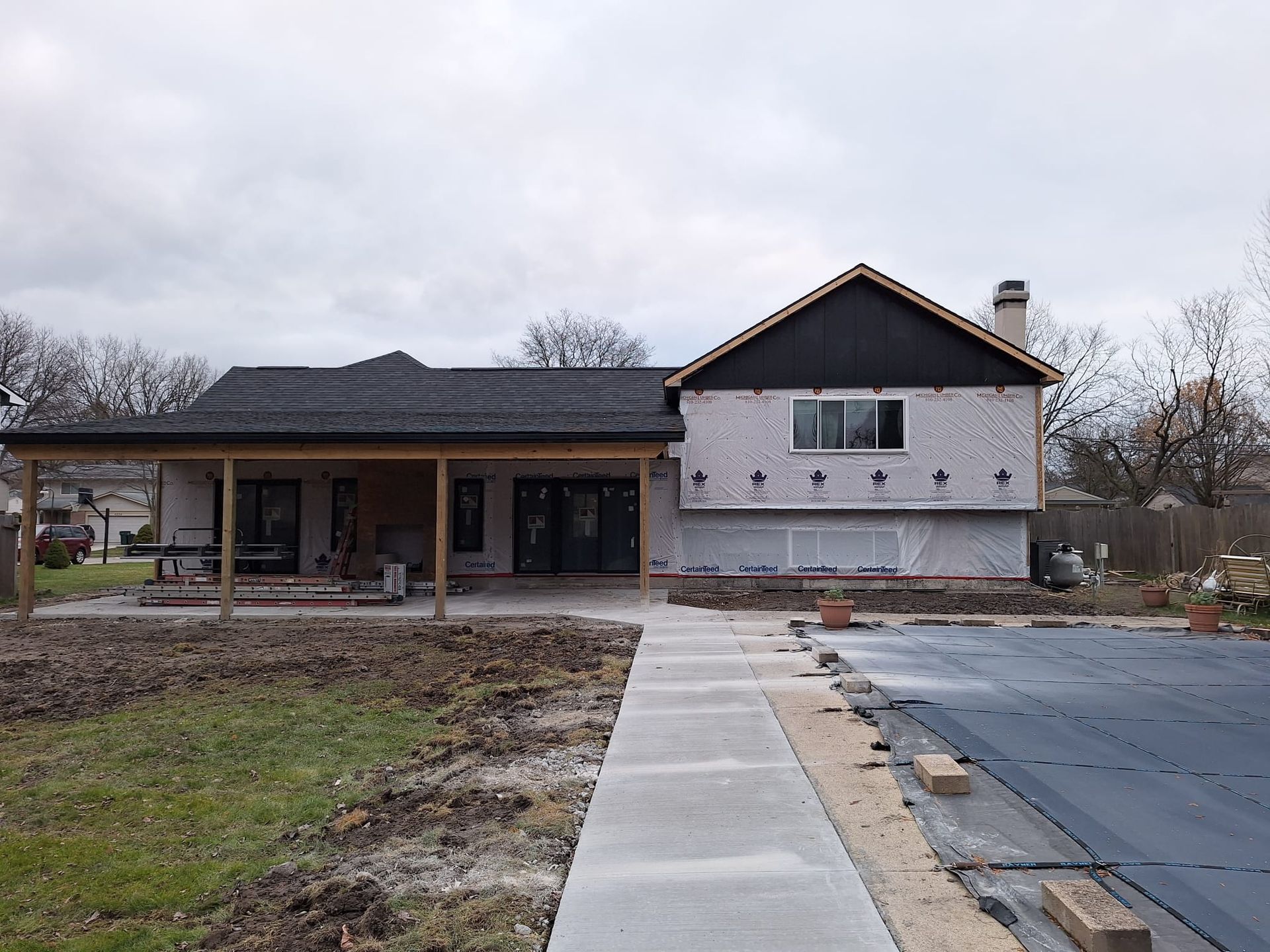 A house under construction with a concrete walkway leading to it