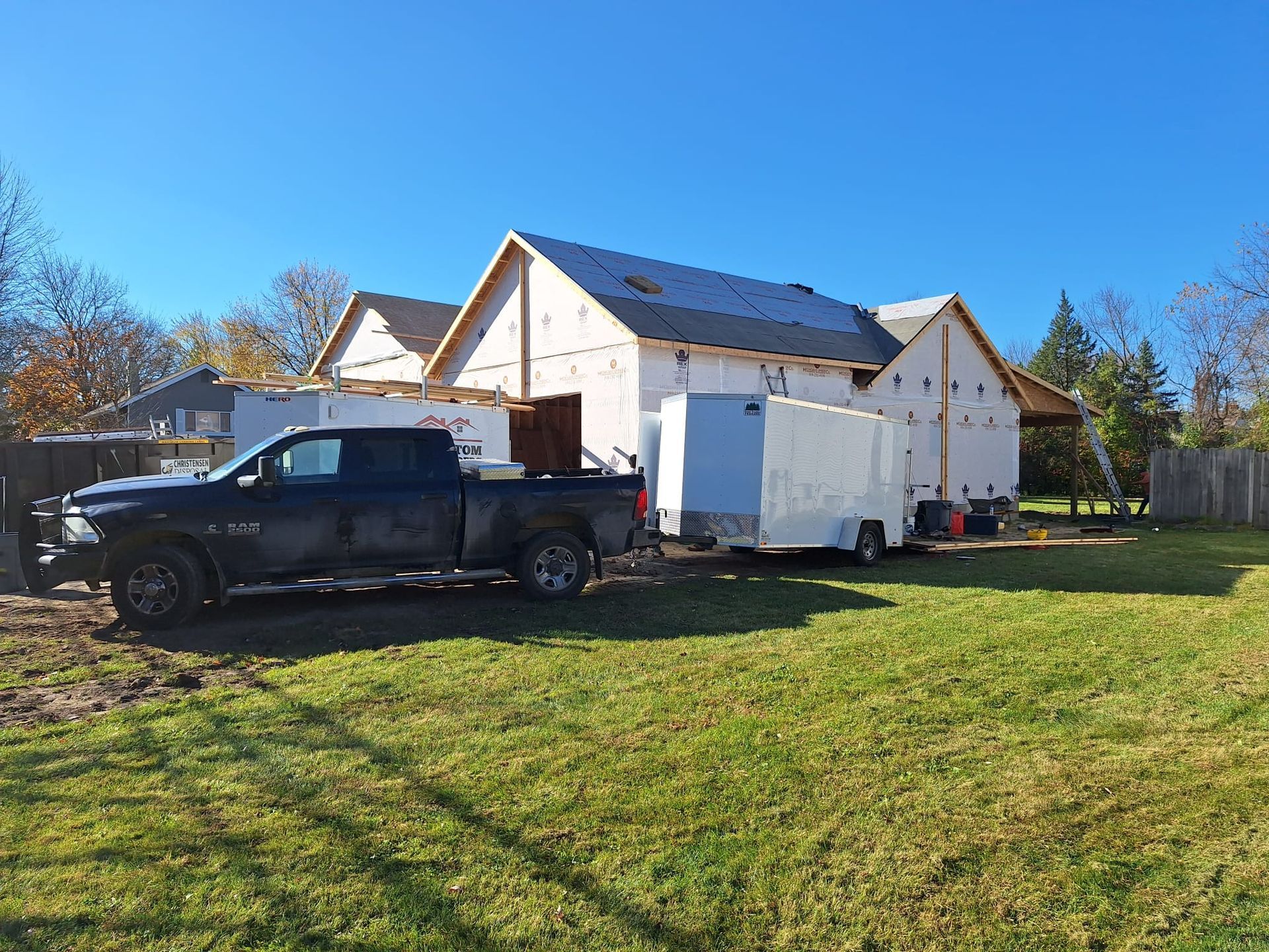 A truck is parked in front of a house under construction