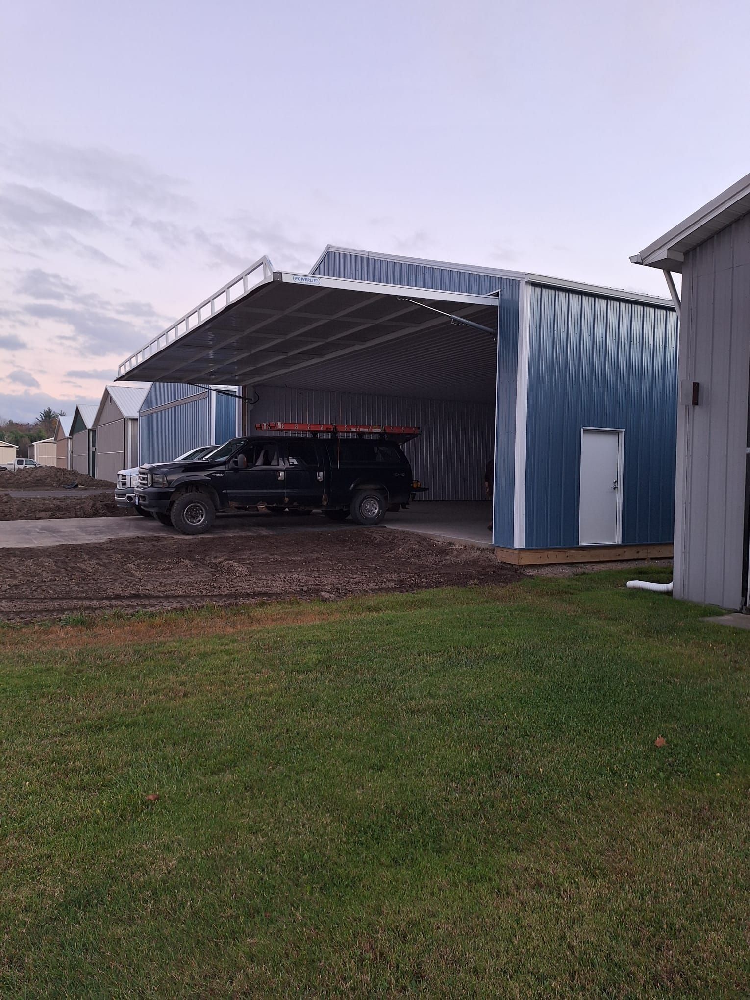 A black suv is parked in front of a blue building.