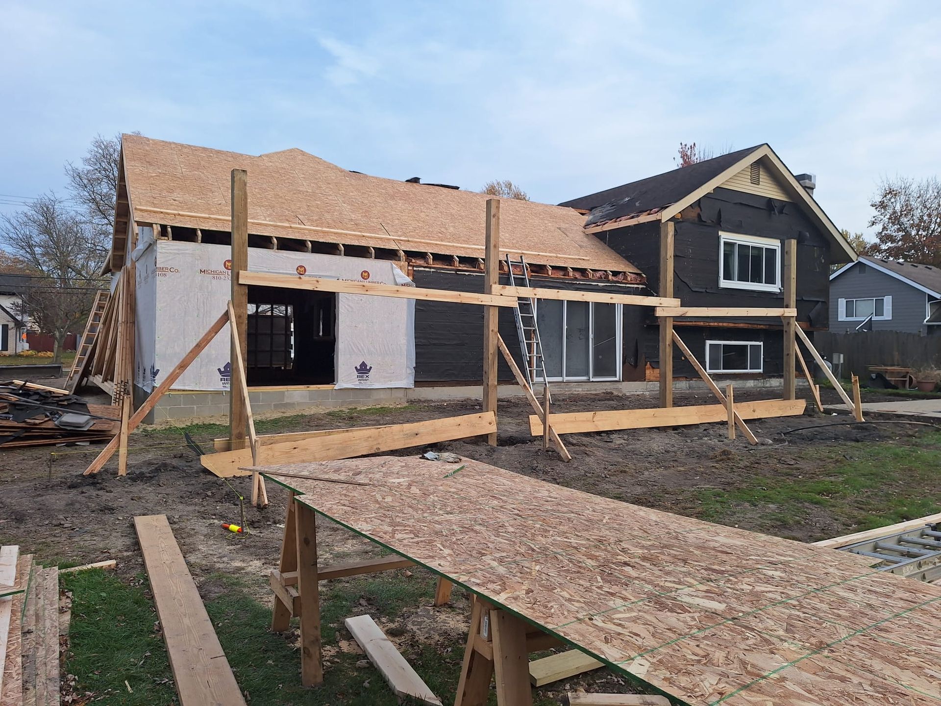 A house under construction with a wooden walkway in front of it.