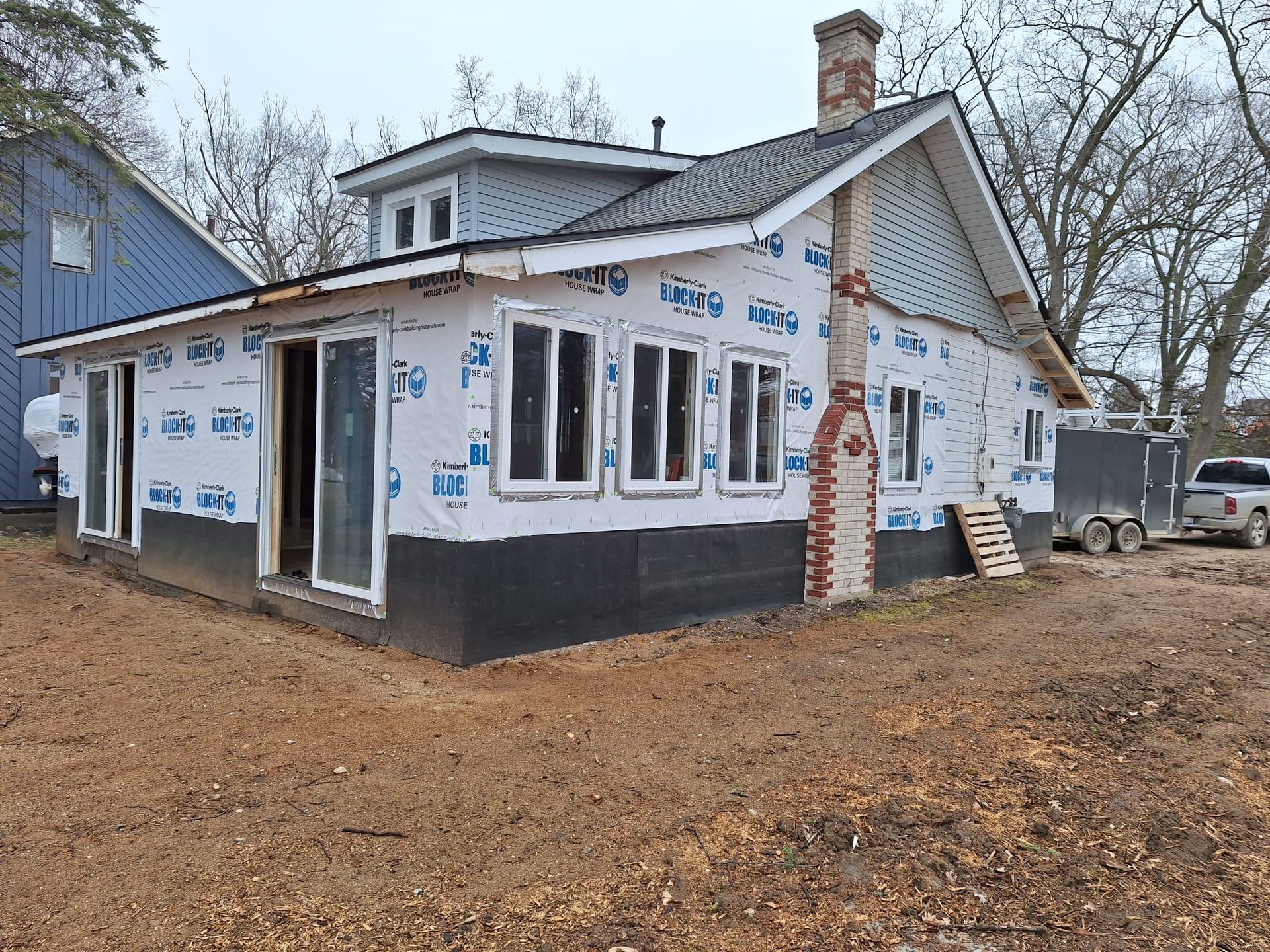 A house is being built in the middle of a dirt field.