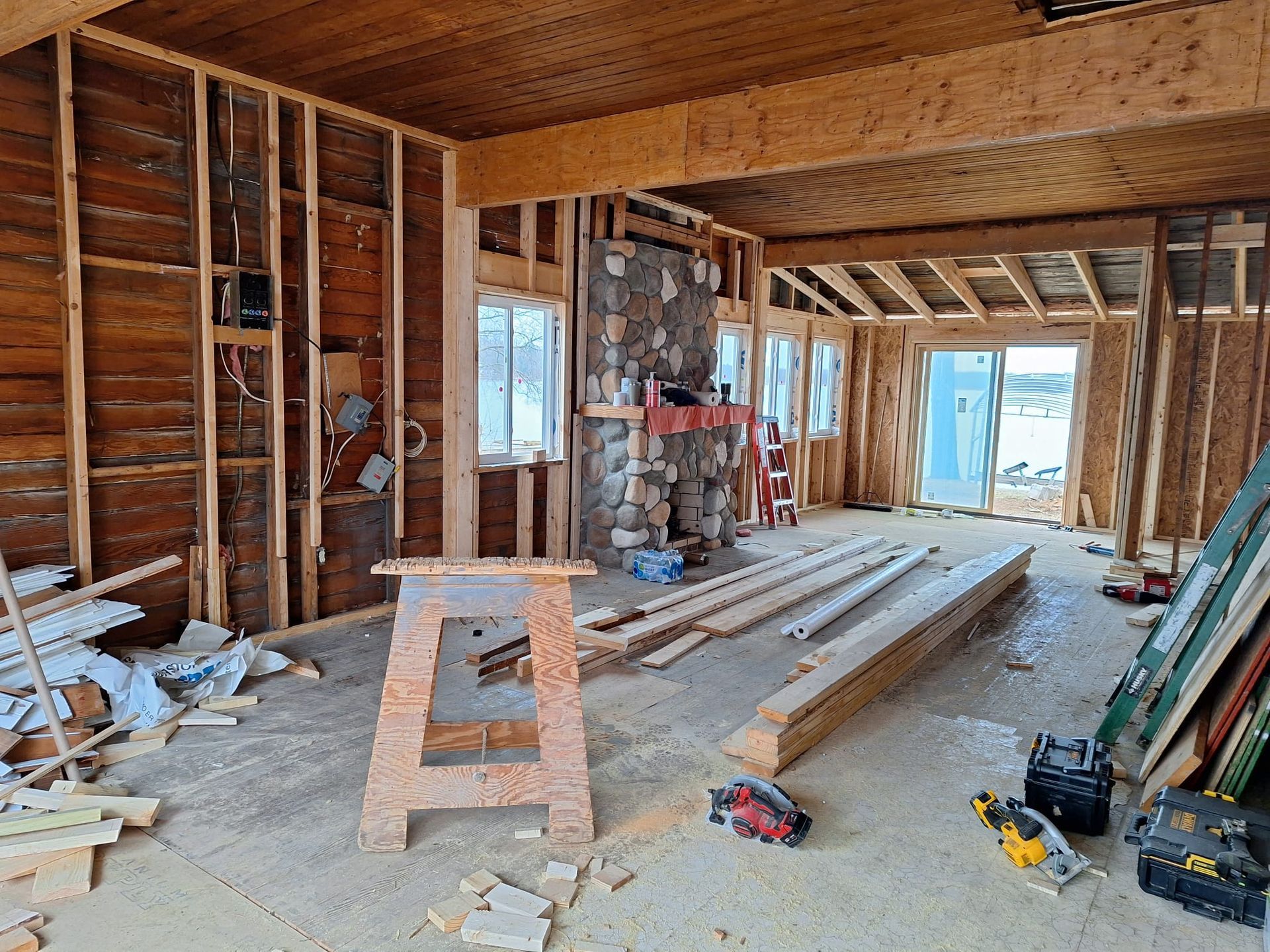 A room with wooden walls and a fireplace under construction.