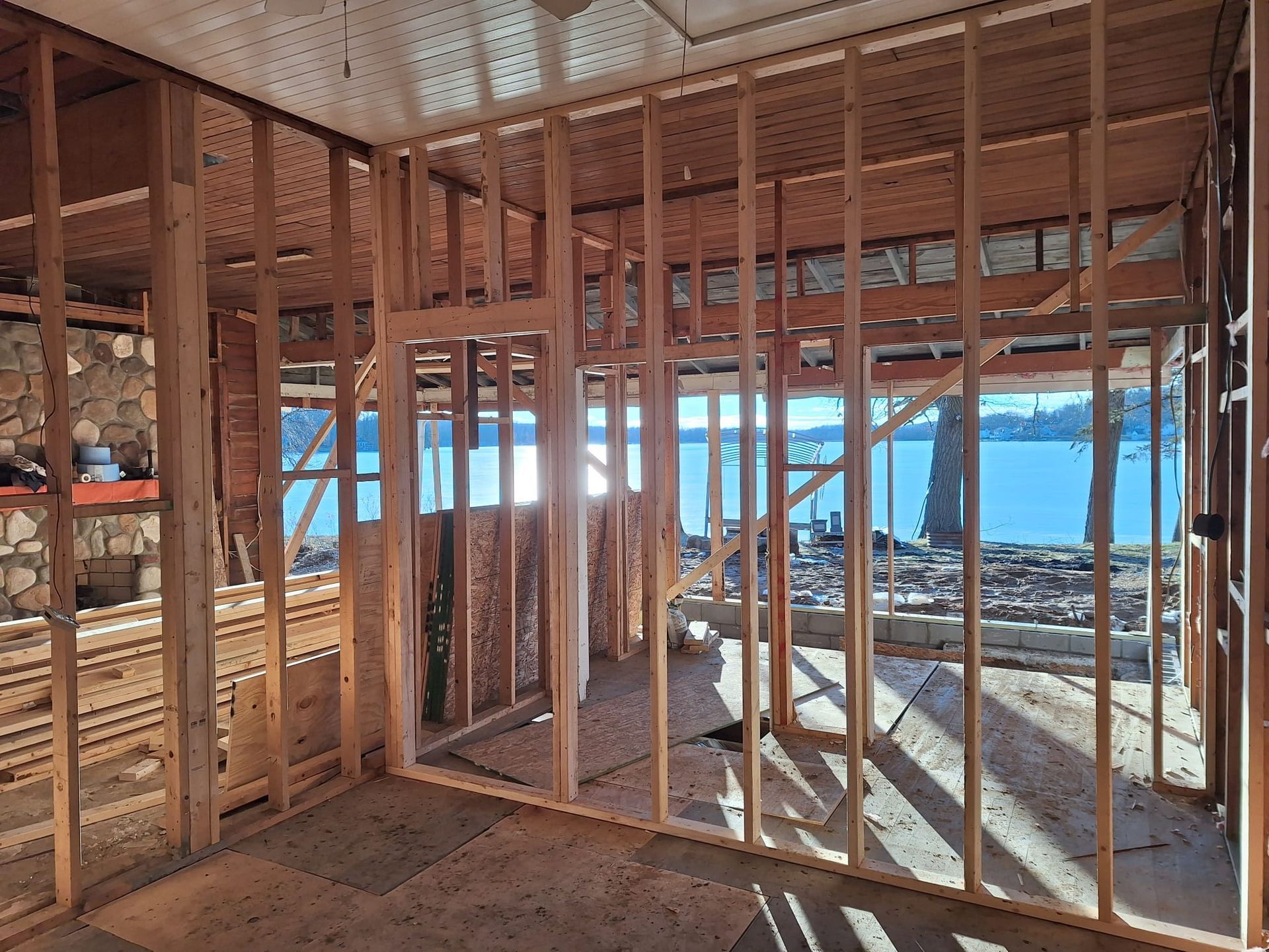 A room in a house under construction with a view of the water.