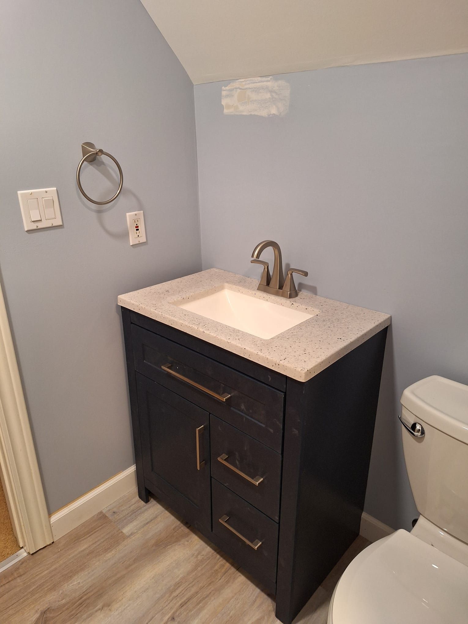 A bathroom with a sink , toilet and towel rack.