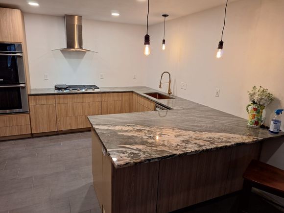 A kitchen with granite counter tops and wooden cabinets