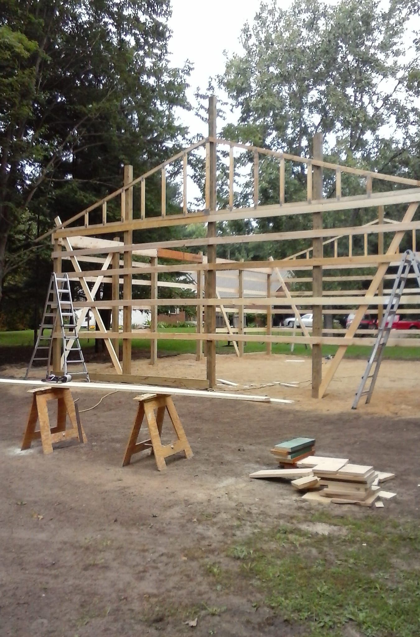 A wooden structure is being built in a dirt field