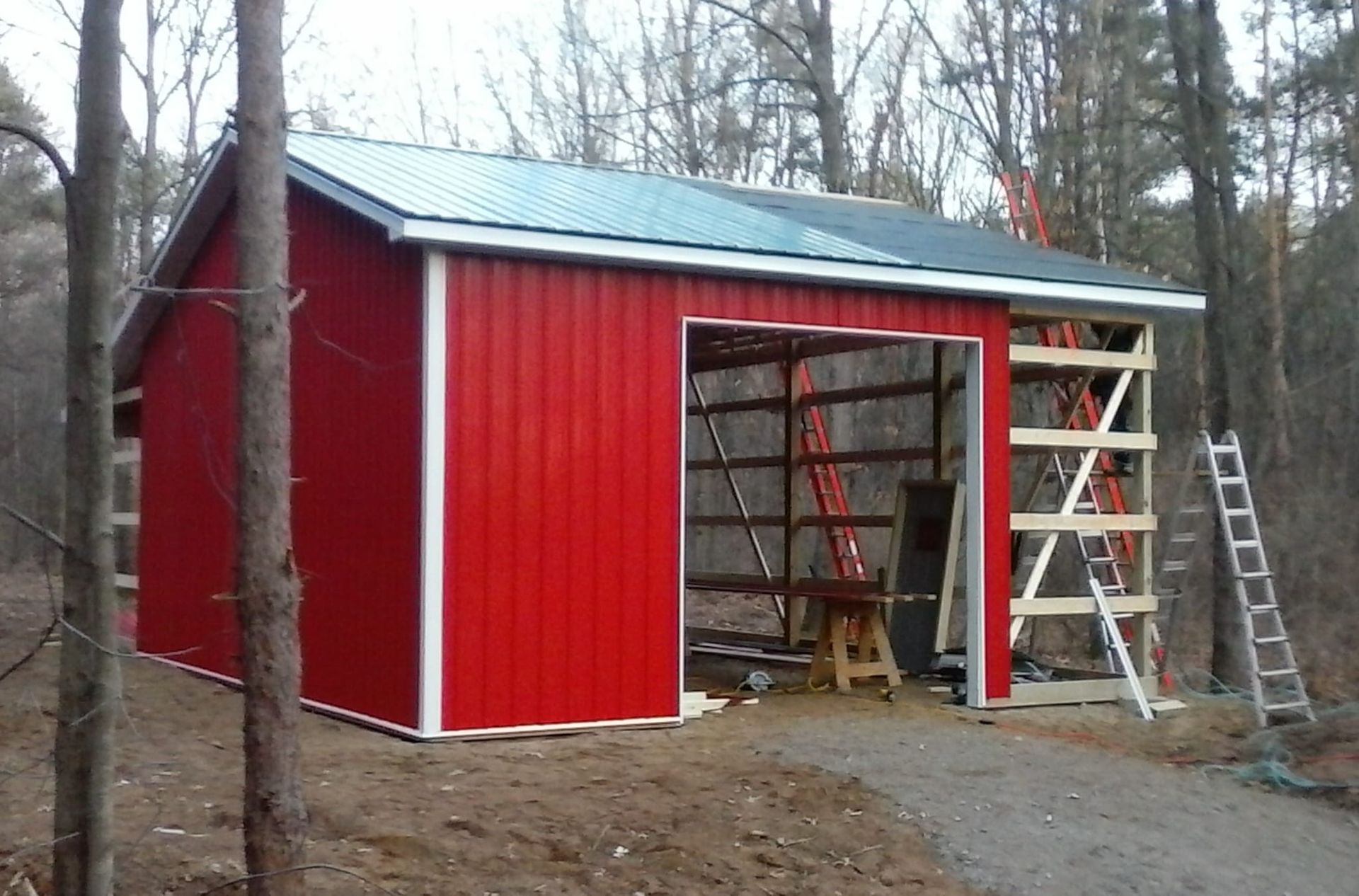 A red barn with a green roof is being built