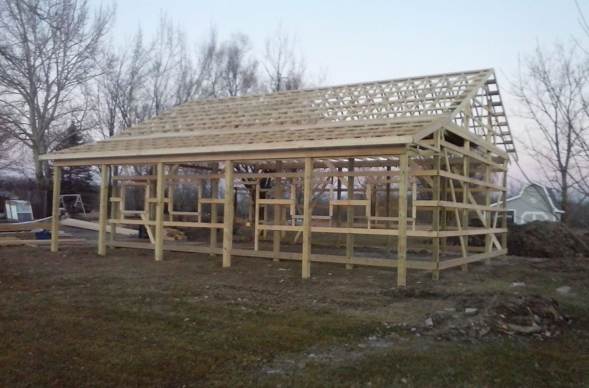A large wooden structure is being built in a field