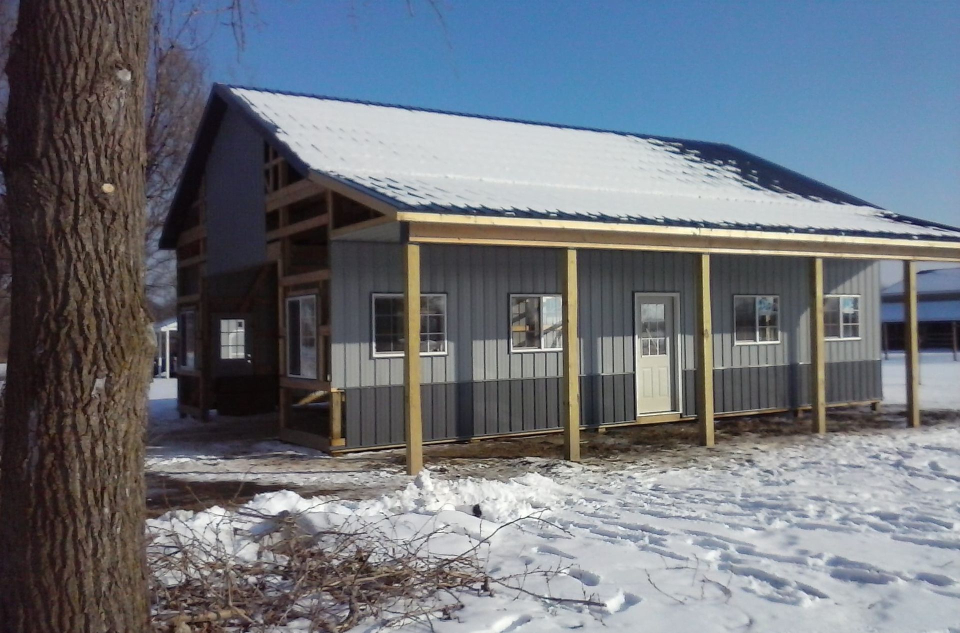 A house with a porch is surrounded by snow