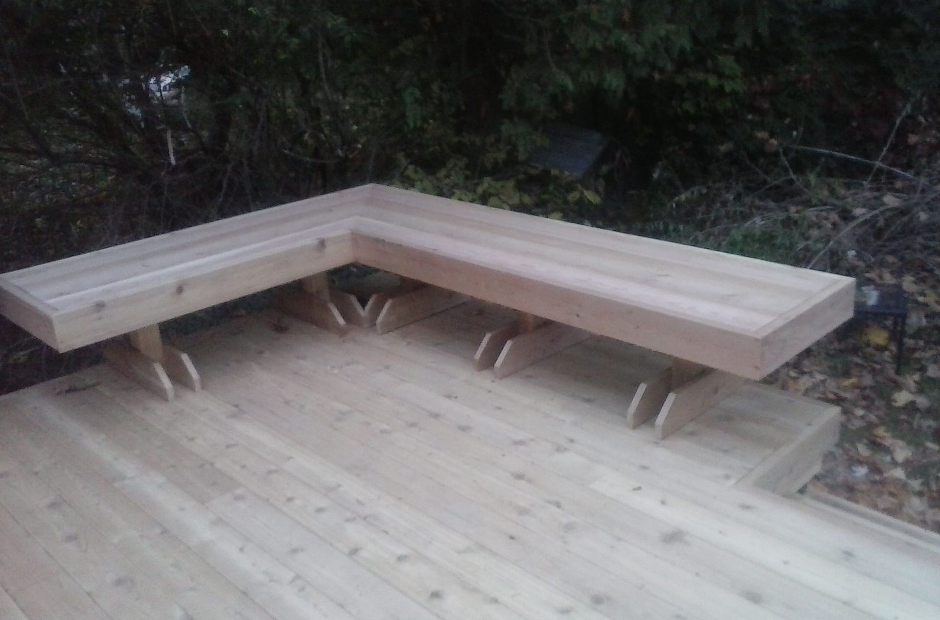 A wooden bench is sitting on a wooden deck