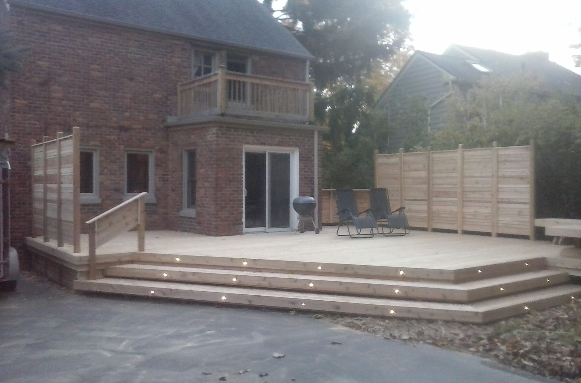 A brick house with a wooden deck in front of it