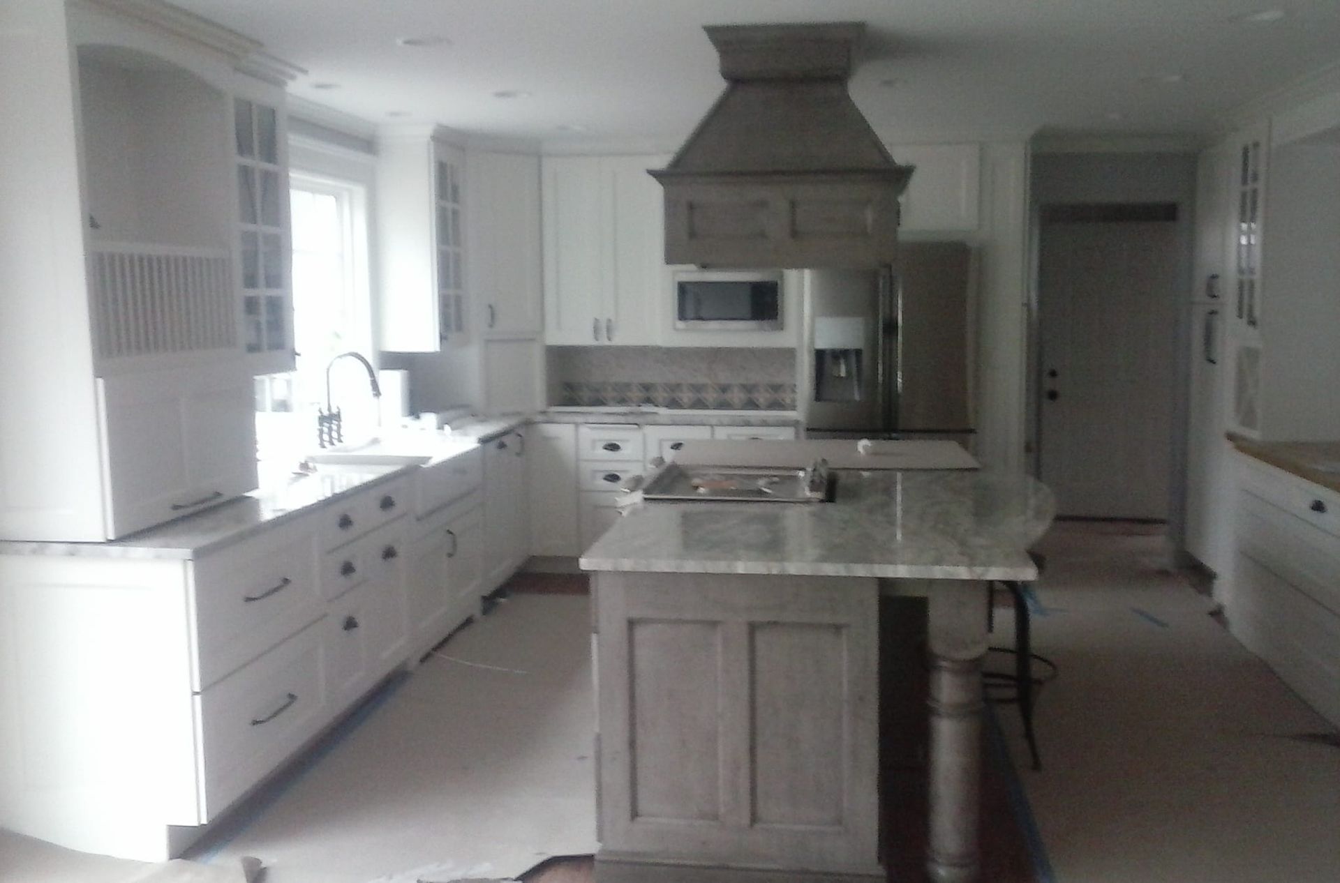 A kitchen with white cabinets and a large island