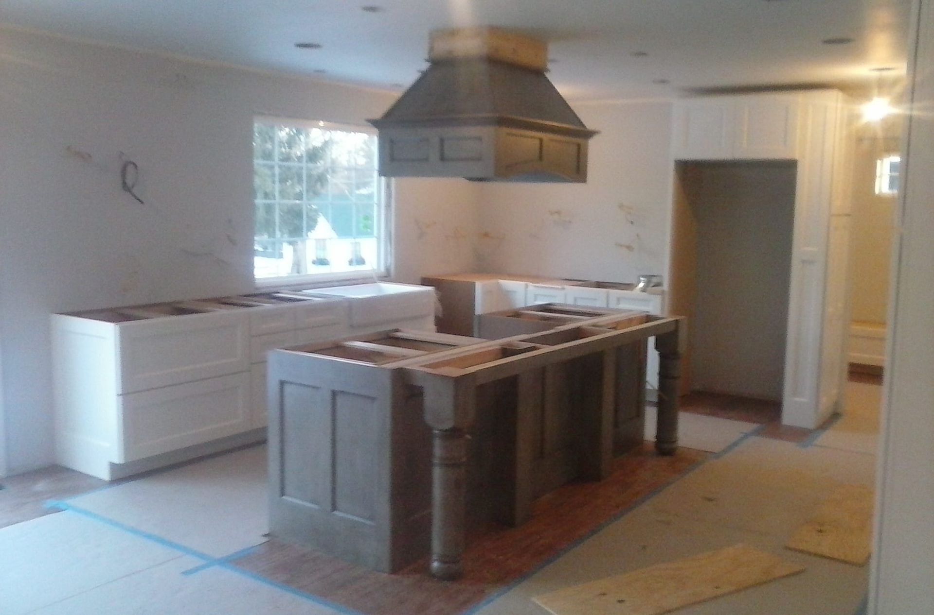 A kitchen under construction with a large island in the middle