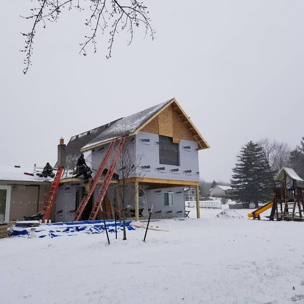 A house under construction in the snow with a playground in the background