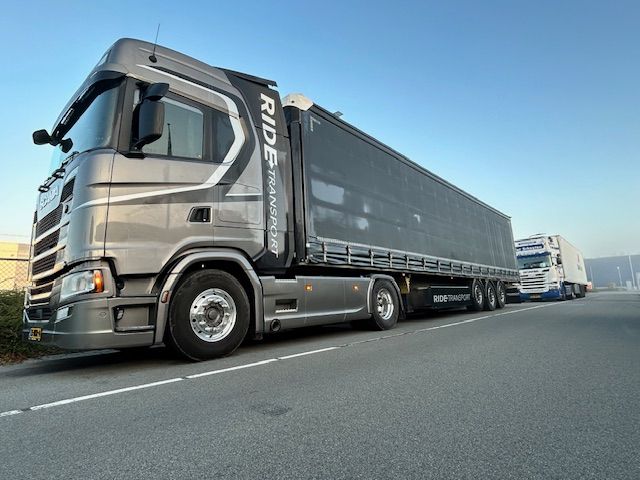 Grijze vrachtwagen met lange oplegger