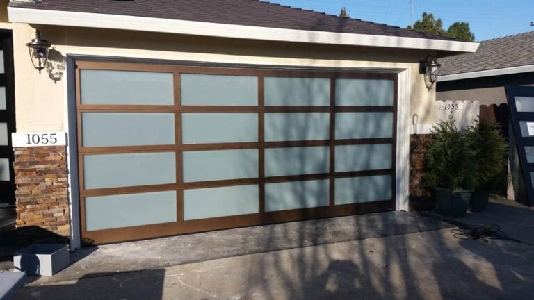 A garage door with a sliding glass door is sitting in front of a house.