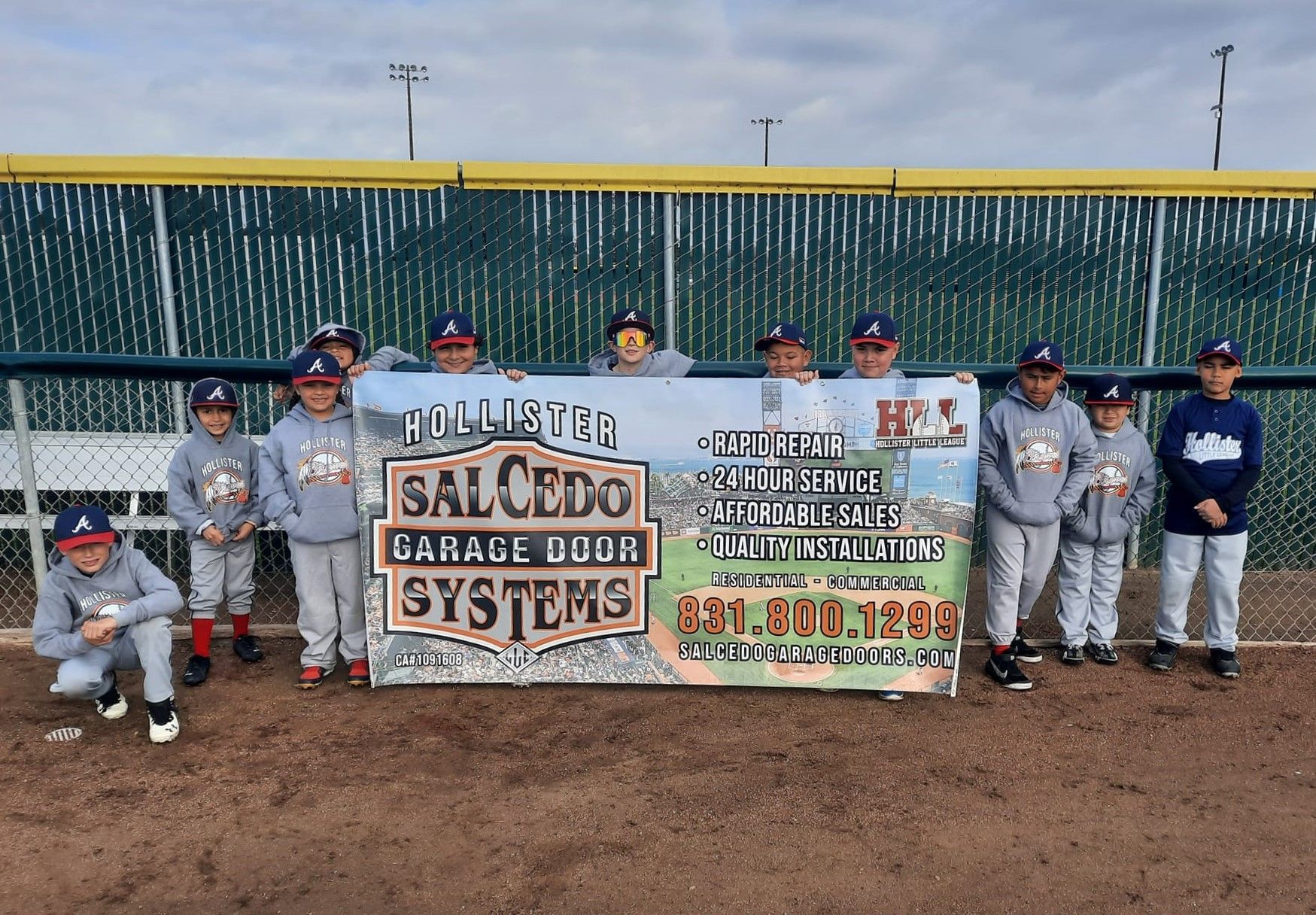 A group of baseball players holding a sign that says salcedo systems
