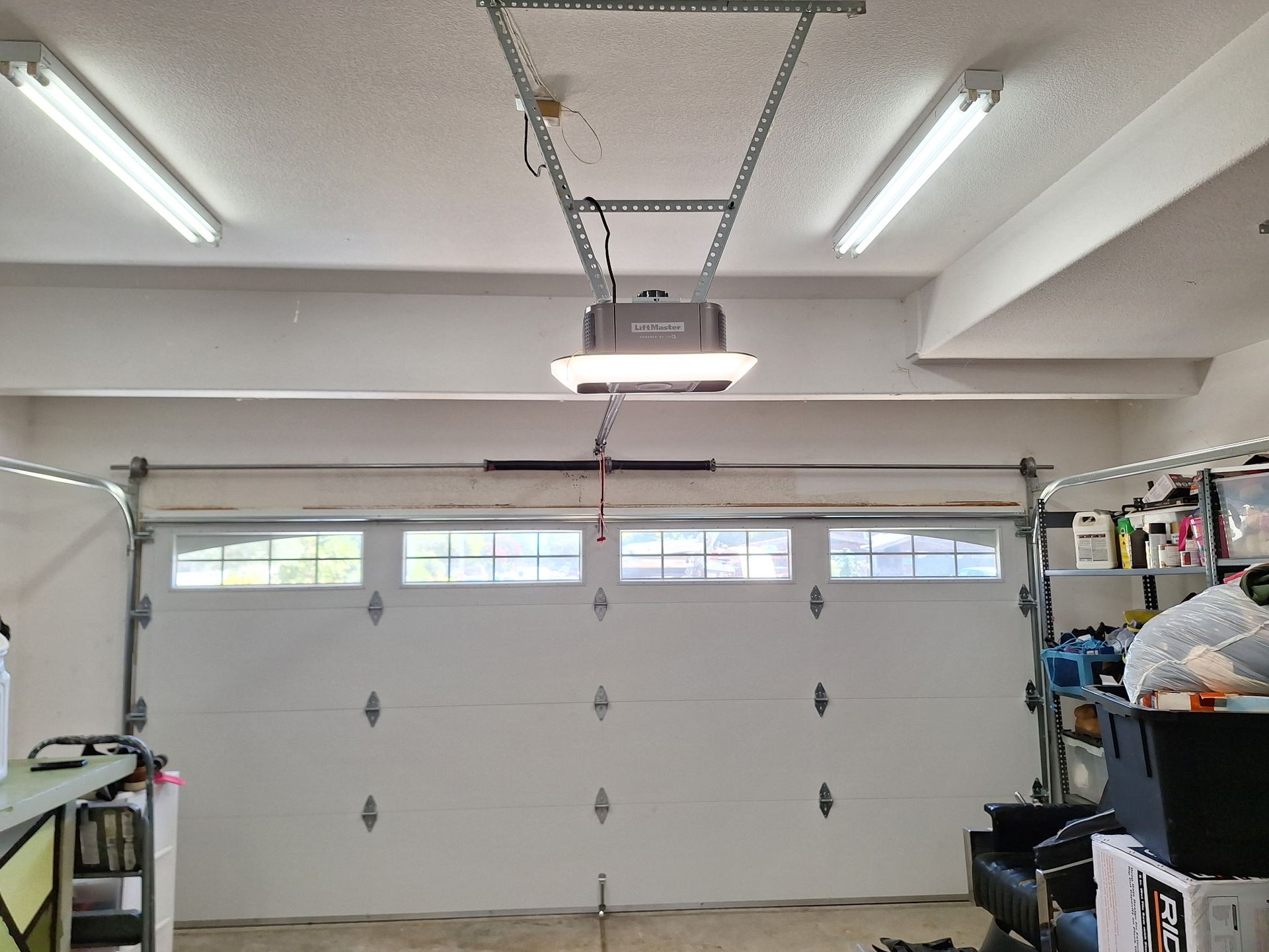 A white truck is parked in front of a white garage.