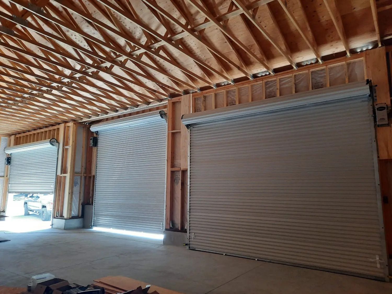 A large building under construction with a lot of rolling garage doors.